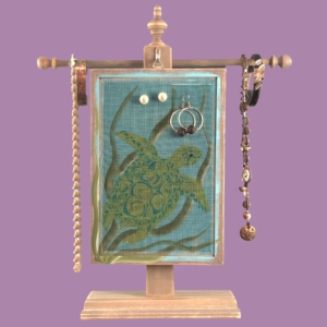 Hand-painted Earring Holder with Sea Turtles Design — weathered gray solid wood frame with fiberglass screen earring display area hanging on necklace stand. Handmade in Michigan.