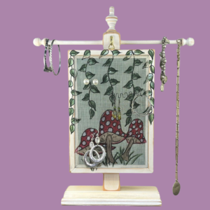 Hand-painted Earring Holder with Mushrooms Design — solid wood white distressed frame with fiberglass screen earring display area hanging on necklace stand. Handmade in Michigan.