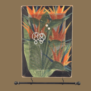 Hand-painted jewelry organizer - Portrait Series Bird of Paradise Design - on a black distressed solid wood frame and a decorative fiberglass screen as the earring holder surface. A matching jewelry bar hangs from the frame.