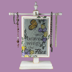 Hand-painted Earring Holder with Brave Wings Design — solid wood white distressed frame with fiberglass screen earring display area hanging on necklace stand. Handmade in Michigan.