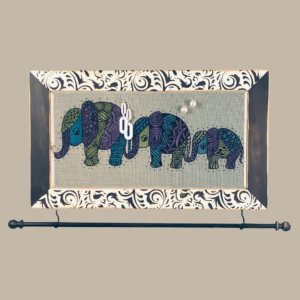 Hand-painted jewelry organizer - Studio Series Elephants Design - on a black and white distressed solid wood frame and a decorative fiberglass screen as the earring holder surface. A matching jewelry bar hangs from the frame.