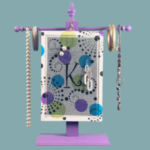 Hand-painted Personalized Earring Holder with Confetti Design — white and purple solid wood frame with fiberglass screen earring display area hanging on necklace stand. Handmade in Michigan.