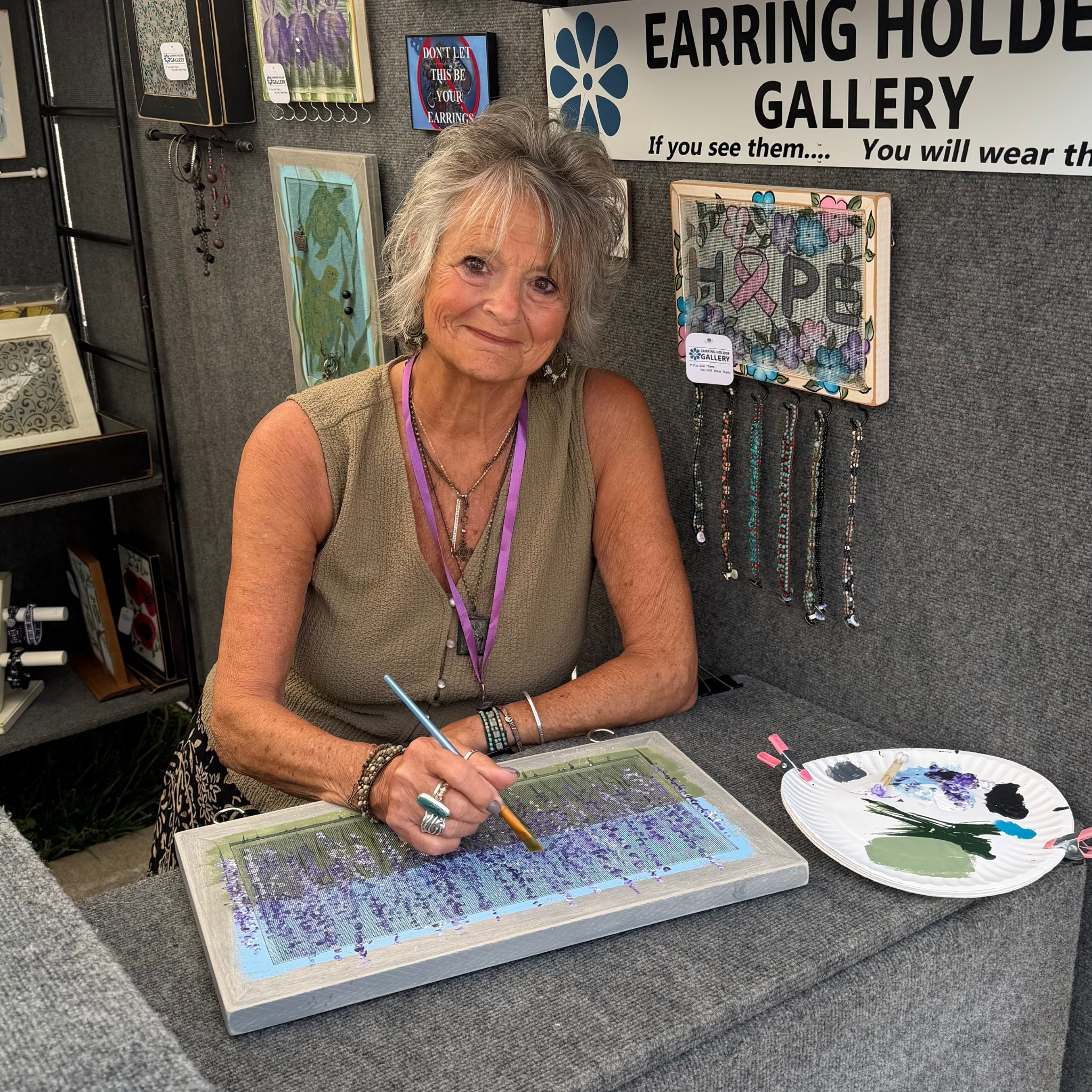 Barb painting an earring holder at the Talbot Street Art Fair
