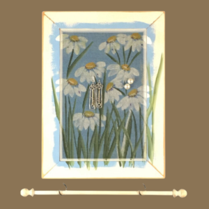 Hand-painted jewelry organizer - Portrait Series Daisies Design - on a white distressed solid wood frame and a decorative fiberglass screen as the earring holder surface. A matching jewelry bar hangs from the frame.